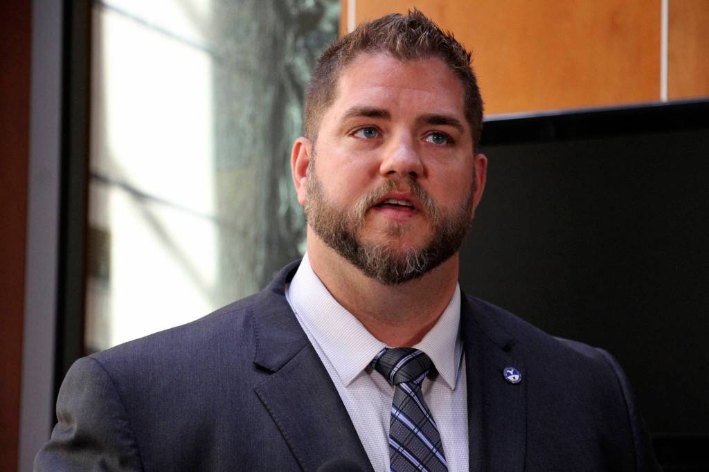 Alaska health commissioner Adam Crum speaks at a news conference Monday, Aug. 5, 2019, in Anchorage, Alaska. State health department officials discussed proposals they are seeking for a study on the feasibility of privatizing Alaskas state-owned psychiatric hospital and announced the Alaska Psychiatric Institute is in good standing with federal requirements. (AP Photo/Mark Thiessen)