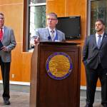 Deputy Alaska health commissioner Albert Wall speaks at a news conference Monday, Aug. 5, 2019, in Anchorage, Alaska, while Gov. Mike Dunleavy, left, and health commissioner Adam Crum, right, look on. State health department officials discussed proposals they are seeking for a study on the feasibility of privatizing Alaskas state-owned psychiatric hospital and announced the Alaska Psychiatric Institute is in good standing with federal requirements. (AP Photo/Mark Thiessen)
