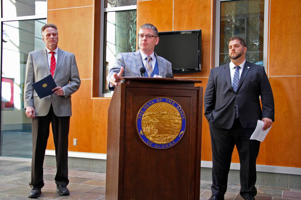 Deputy Alaska health commissioner Albert Wall speaks at a news conference Monday, Aug. 5, 2019, in Anchorage, Alaska, while Gov. Mike Dunleavy, left, and health commissioner Adam Crum, right, look on. State health department officials discussed proposals they are seeking for a study on the feasibility of privatizing Alaskas state-owned psychiatric hospital and announced the Alaska Psychiatric Institute is in good standing with federal requirements. (AP Photo/Mark Thiessen)