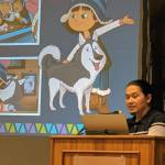 University of Alaska Southeast professor Xunei Lance Twitchell filled in for the Evening at Egan presentation about Molly of Denali Friday, Nov. 30, 2018. He introduced the crowd at UASs Egan Library to the shows characters, including Mollys dog, Suki. (Ben Hohenstatt | Juneau Empire File)