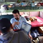 IBU representative Earling Walli, center, helps union members sign up online for the ratification vote inside a converted school bus at the Auke Bay ferry terminal on Friday, August 2, 2019 (Peter Segall | Juneau Empire)