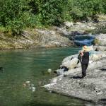 Marta Lastufka and her husband, Michael Bucy, watch their dog, Mo, swim in Gold Creek at Cope Park on Tuesday, Aug. 6, 2019. (Michael Penn | Juneau Empire)