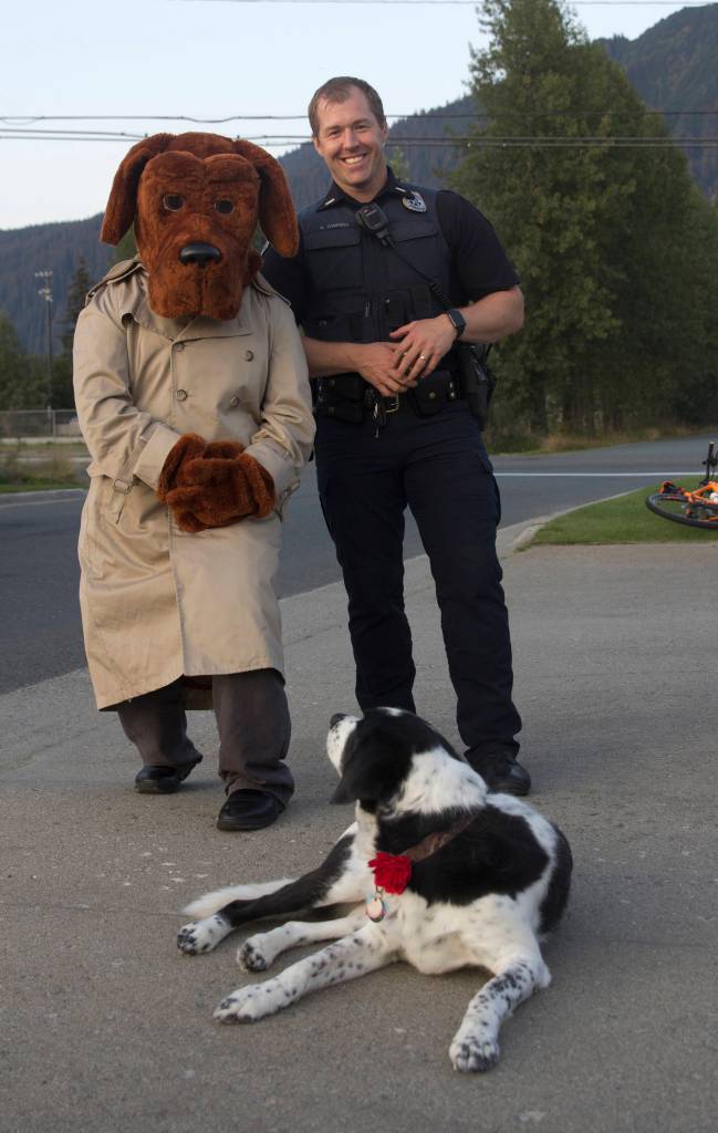 Lt. Krag Campbell, patrol lieutenant with Juneau Police Department, and McGruff the Crime Dog, pose with Delta, a somewhat confused neighborhood resident during the National Night Out, Aug. 6. (Michael S. Lockett | Juneau Empire)