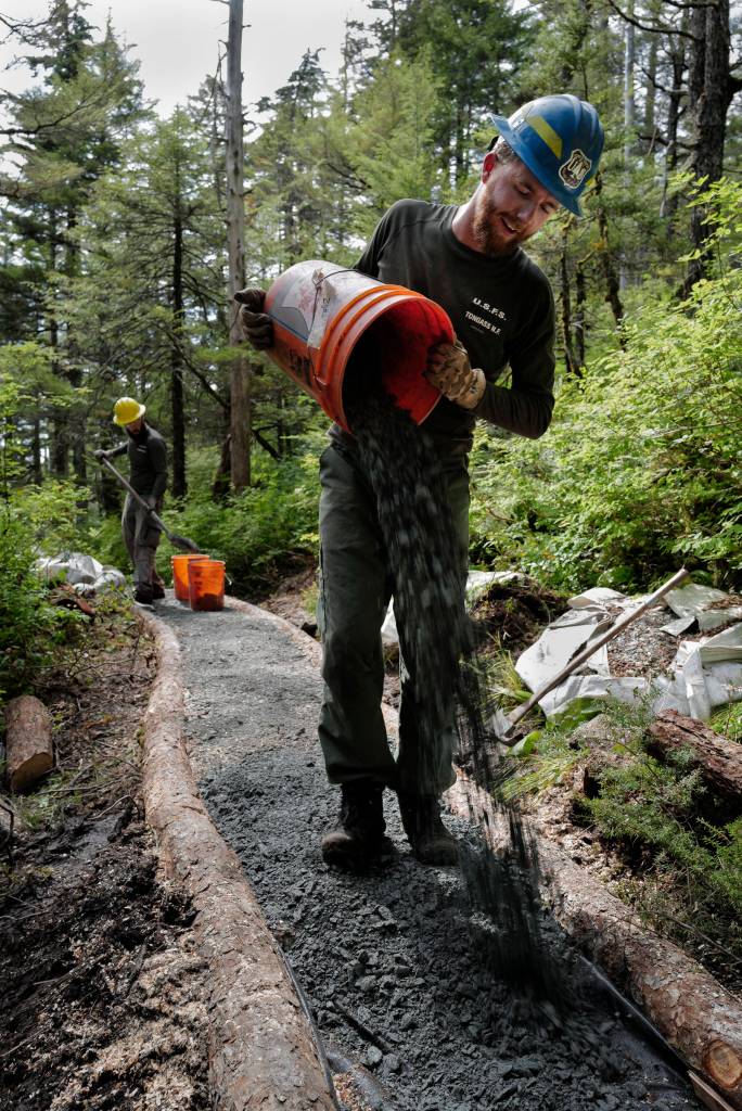 Jase Tweedy, right, and Lou Eney work on the Auke Nu Trail on the way to the John Muir Cabin on Wednesday, Aug. 7, 2019. (Michael Penn | Juneau Empire)