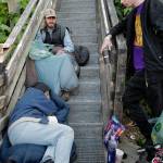 Homeless people spend their time on the Decker Way stairs after the Glory Halls closure on Tuesday, Aug. 13, 2019. The emergency shelter and soup kitchen is closing their doors from 7 a.m. to 2 p.m. daily due to budget cuts forcing their homeless clients to find other places to be. Oatmeal and coffee were available to clients before leaving the shelter but no lunch is available. (Michael Penn | Juneau Empire)