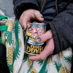 Justin Fairclough, who said he has stayed on and off at the Glory Hall over the last four years, holds a can of chili in front of the Juneau Downtown Library on Tuesday, Aug. 13, 2019. Fairclough said he had no way of heating the food for lunch. (Michael Penn | Juneau Empire)