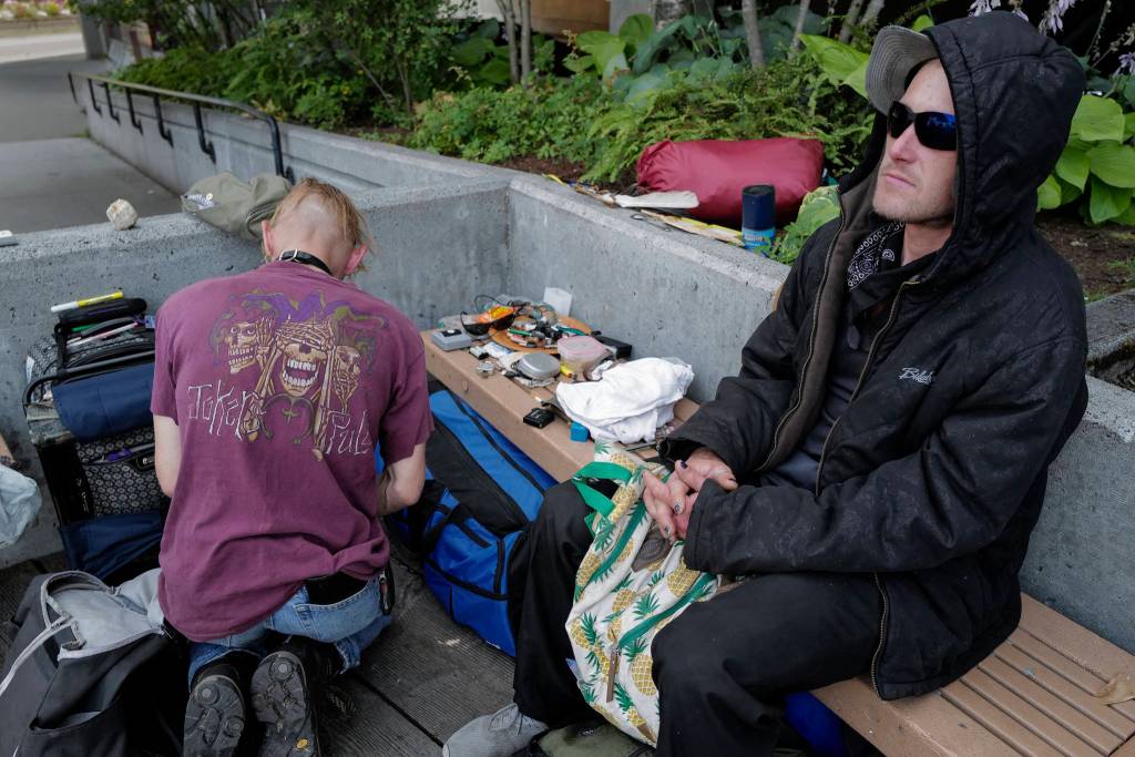 Justin Fairclough, right, and Keoki Cunningham organize their belongings and hang out in front of the Juneau Downtown Library on Tuesday, Aug. 13, 2019. They are currently staying at the Glory Hall at night. (Michael Penn | Juneau Empire)