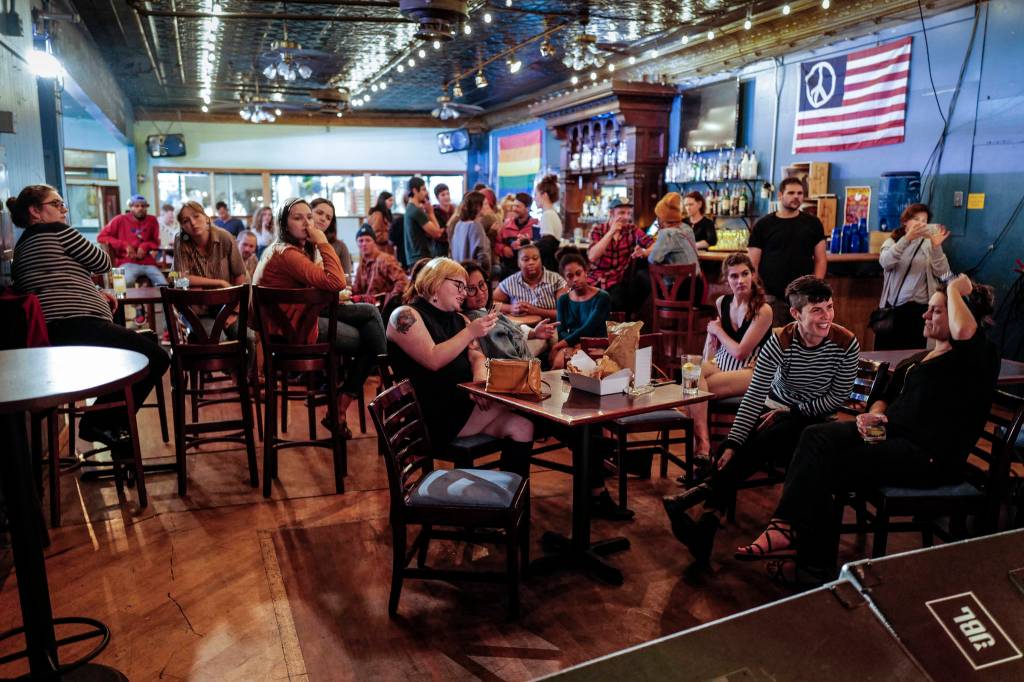An audience watches a painting performance during the GRLZ open mic night at the The Rendezvous Bar on Wednesday, Aug. 14, 2019. (Michael Penn | Juneau Empire)