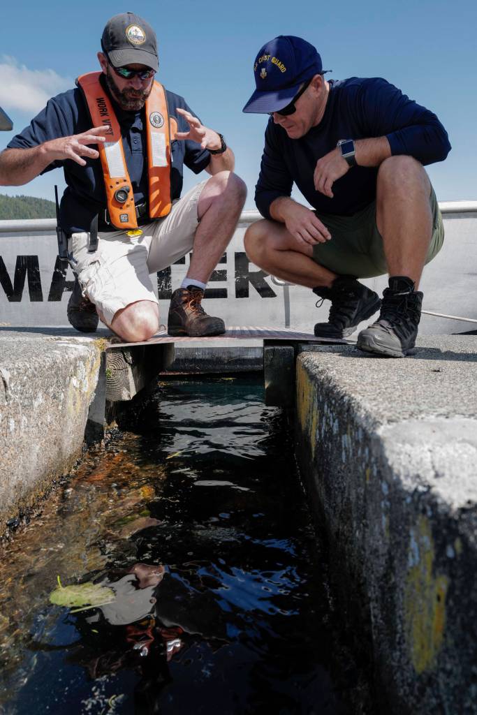 Deputy Harbormaster Matt Creswell, left, explains to the project to Shawn Price, of U.S. Coast Guard Regional Dive Locker West, at the Don D. Statter Boat Harbor in Auke Bay on Friday, Aug. 16, 2019. Members of the U.S. Armys 74th Engineer Dive Detachment and U.S. Coast Guard Regional Dive Locker West worked together to inspect and replace the bolts holding the harbors breakwater together. (Michael Penn | Juneau Empire)
