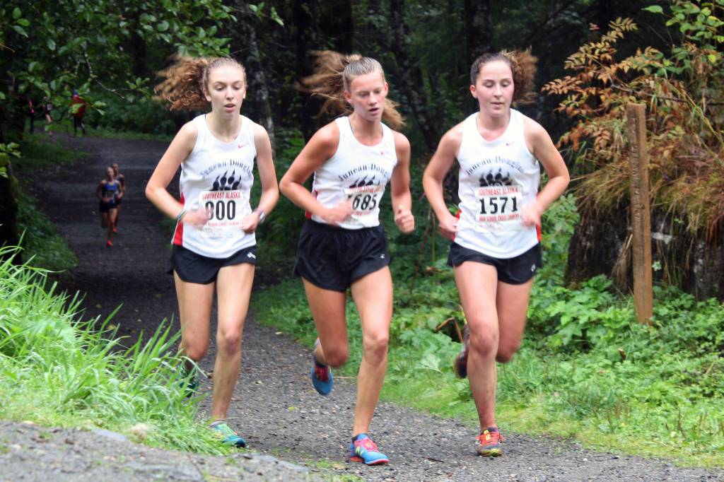 Juneau-Douglas High School: Yadaat.at Kales Anna Iverson, left, Skylar Tuckwood, middle, and Katie McKenna run in the Douglas Island Mini-Meet on the Treadwell Mine Historical Trail on Saturday, Aug. 17, 2019. The trio finished within 10 seconds of each other to claim the second (Tuckwood), third (Iverson) and fourth (McKenna) spots in the girls 5-kilometer run. (Nolin Ainsworth | Juneau Empire)