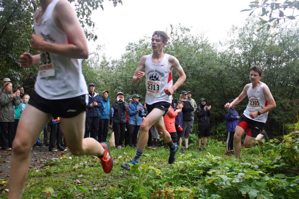 Juneau-Douglas High School: Yadaat.at Kales Aubrey Hekkers, left, Will Robinson, middle, and Sam Holst round a corner of the Treadwell Mine Historic Trail while running in the Douglas Island Mini-Meet on Saturday, Aug. 17, 2019. (Nolin Ainsworth | Juneau Empire)