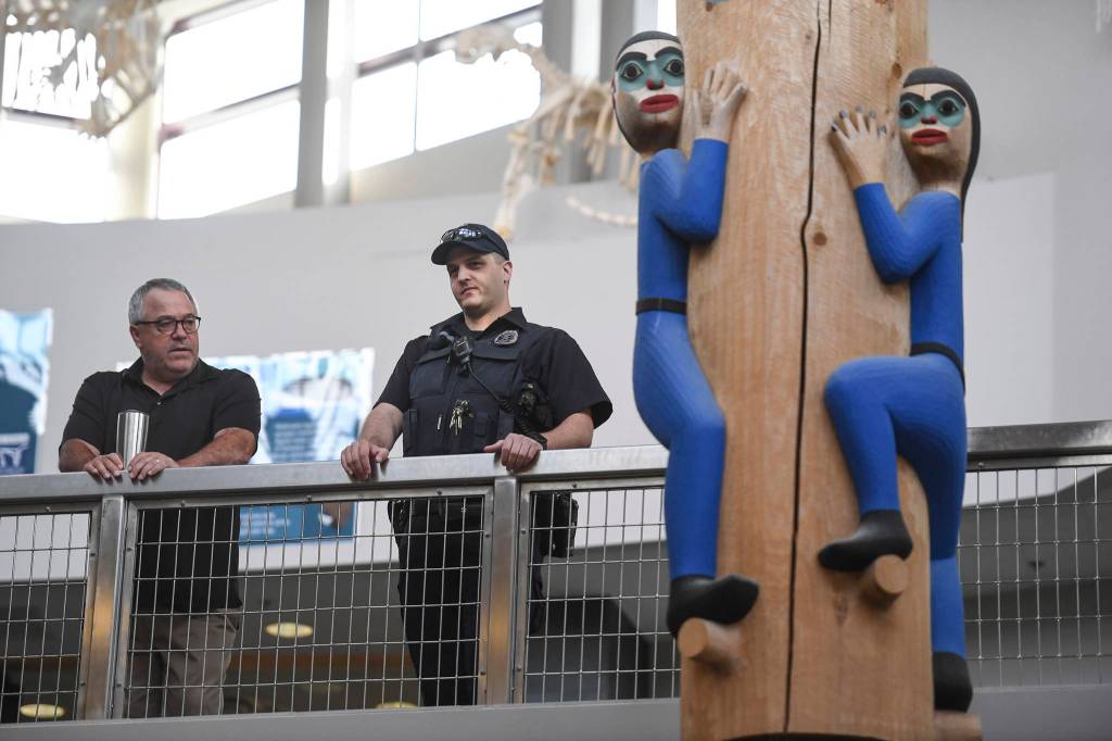 Thunder Mountain High School Principal Dan Larson, left, and Juneau Police Department School Resource Officer John Cryderman watch students arriving on the first day of school on Monday, Aug. 19, 2019. (Michael Penn | Juneau Empire)