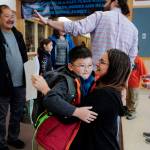 Nghiem Tran, left, watches as his son, William, arrives for second grade and is greeted by Music Teacher Rebecca Ricker on the first day of school at Riverbend Elementary School on Monday, Aug. 19, 2019. (Michael Penn | Juneau Empire)