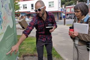 Co-artistic collaborator and facilitators for Juneau Voices Audio Wayfinding Project Ryan Conarro and Lillian Petershoarepoint to existing signage Tuesday, Aug. 20, 2019. The sign will be replaced by one linked to an audio installation in spring or summer of next year. (Ben Hohenstatt | Juneau Empire)