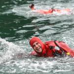 Seaman Weston Murdock of the U.S. Coast Guard Cutter Henry Blake, competes in the survival suit swim during the annual Buoy Tender Olympics at Station Juneau on Wednesday, Aug. 21, 2019. (Michael Penn | Juneau Empire)