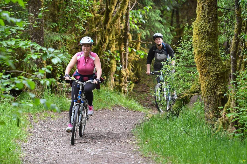 Tana OLeary, left, rides her mountain bicycle with Nicole Dwyer during a womens mountain bike ride at Dredge Lakes on Thursday, June 13, 2019. (Michael Penn | Juneau Empire)