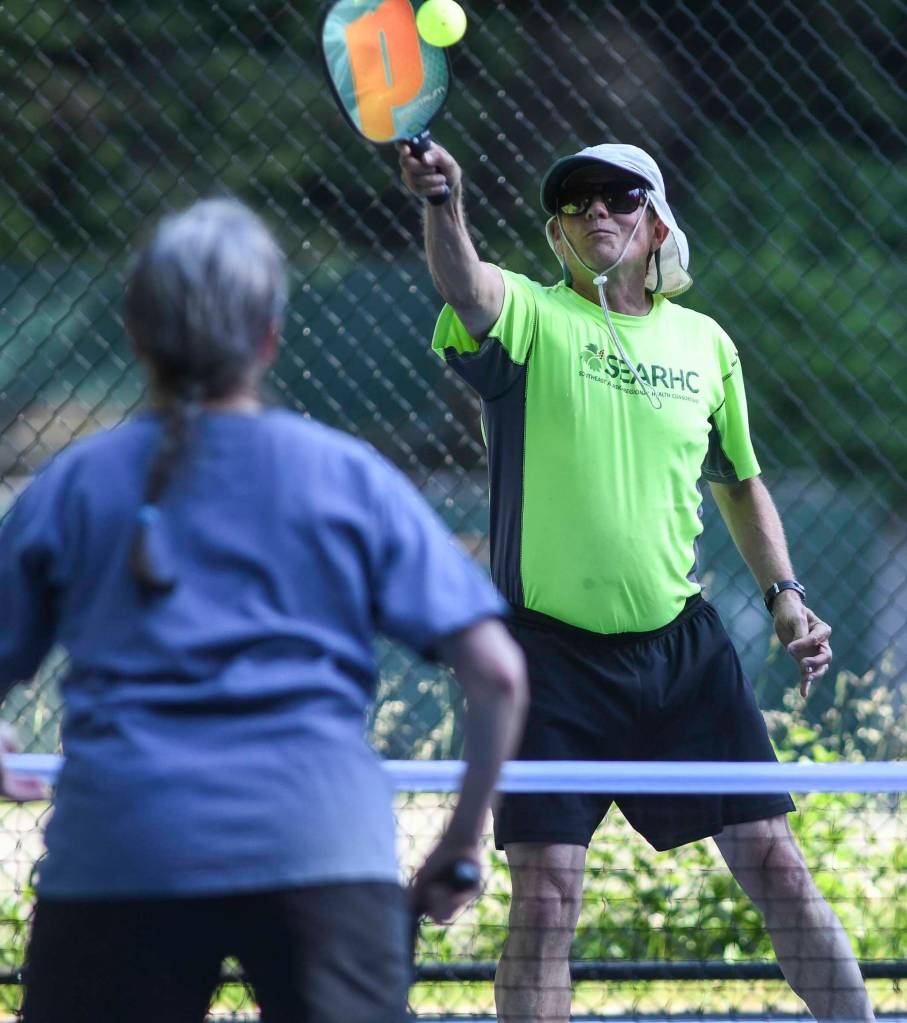 David Job plays the ball during a pickleball match at the Cope Park tennis courts on Wednesday, June 26, 2019. (Michael Penn | Juneau Empire)