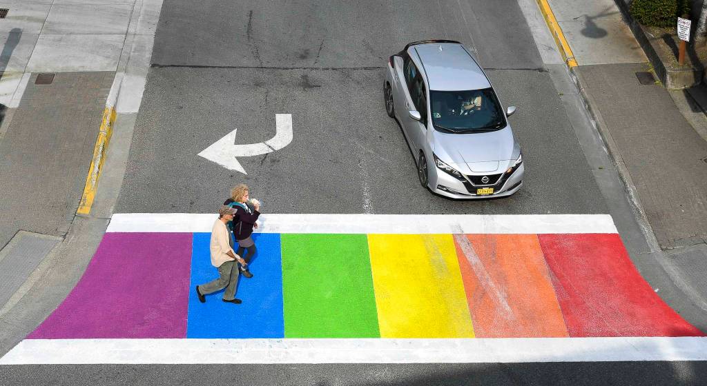 Pedestrians cross Front Street at Main after the city finished painting the crosswalk in rainbow colors on Friday, Aug. 2, 2019. (Michael Penn | Juneau Empire)
