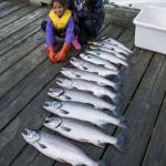 Marie Taug and her daughter, Zoe Tagsip, 9, pose with a dozen coho brought in by their boat to the Mike Pusich Douglas Boat Harbor during the Golden North Salmon Derby on Saturday, Aug. 24, 2019. (Michael Penn | Juneau Empire)