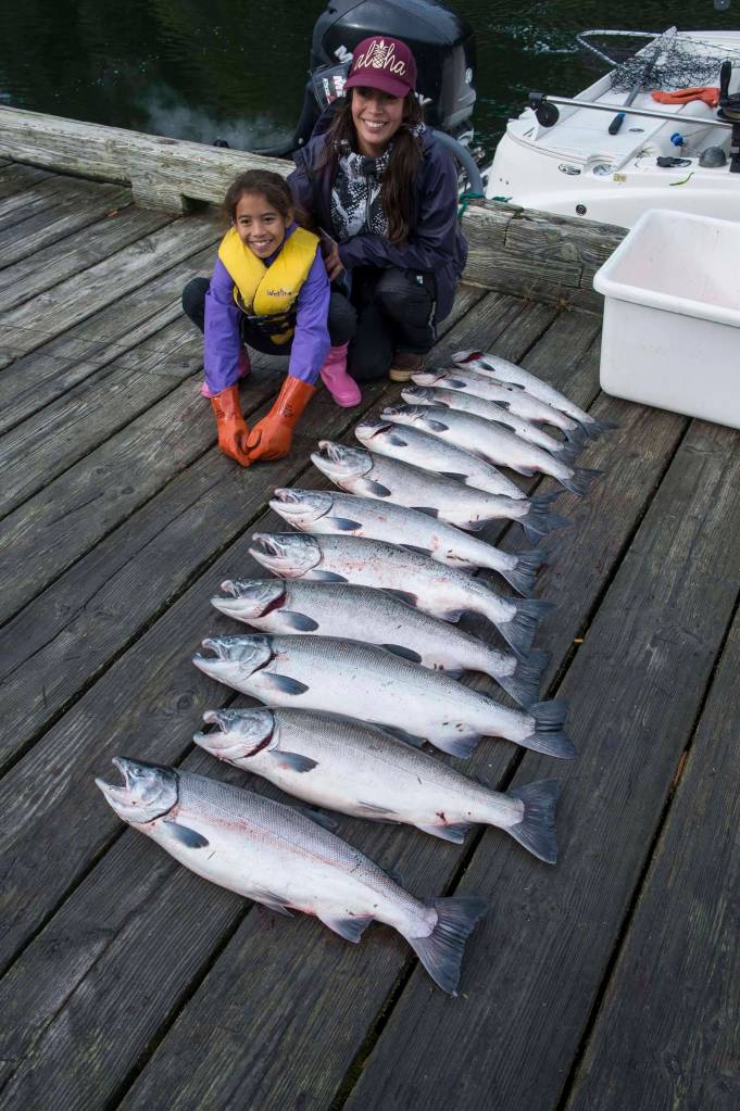 Marie Taug and her daughter, Zoe Tagsip, 9, pose with a dozen coho brought in by their boat to the Mike Pusich Douglas Boat Harbor during the Golden North Salmon Derby on Saturday, Aug. 24, 2019. (Michael Penn | Juneau Empire)