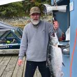 Steven Bogart next to his 24 lbs king salmon at the Mike Pusich Douglas Harbor on Sunday, Aug. 25, 2019. At the time Bogarts king was the derby leader. (Peter Segall | Juneau Empire)