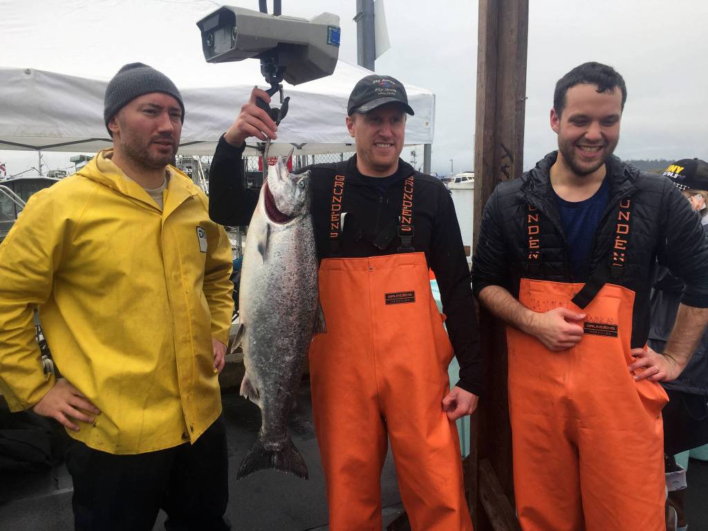 Golden North Salmon Derby participants, from left, Robbie Provost, Zach Forst and Doug Duncan pose with Forsts 19.7-pound king salmon at the Don D. Statter Harbor weigh station. Forst was the first fisherman to turn in a fish at the Auke Bay weigh station, arriving to the dock just after 11 a.m. (Nolin Ainsworth | Juneau Empire)