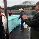 Monika Walker, 36, poses with her her 20.7-pound king salmon as her father Mike Bethers snaps a photo at Don D. Statter Harbor in Auke Bay on Friday, Aug. 23, 2019. (Nolin Ainsworth | Juneau Empire)