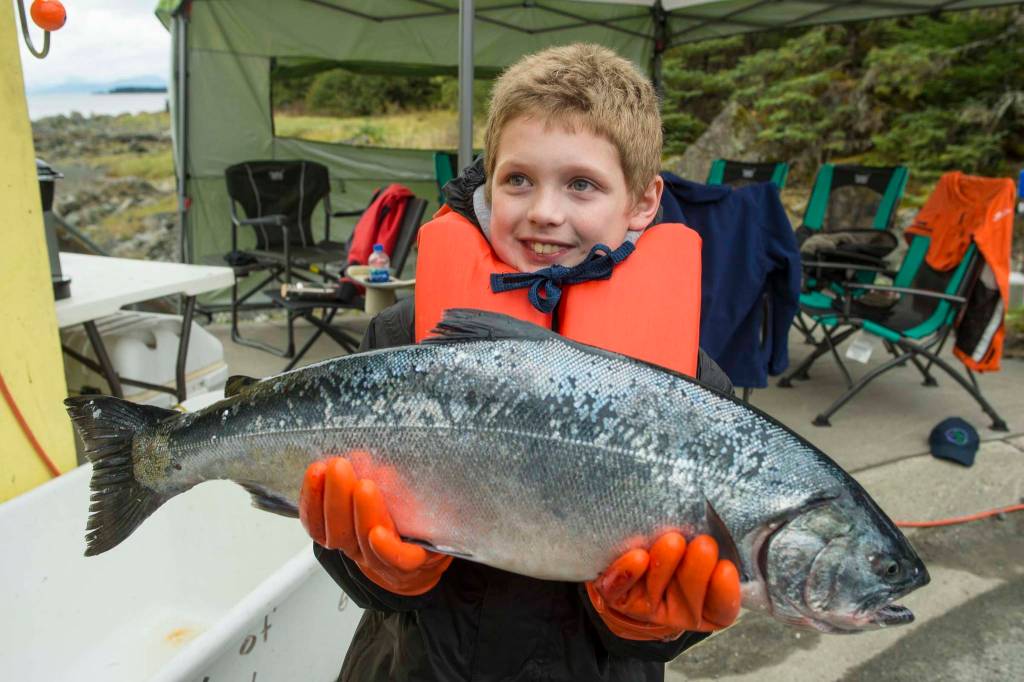 Tito Ritter, 9, holds an 8.5 pound coho he turned in at the Golden North Salmon Derbys station at Amalga Harbor on Saturday, Aug. 24, 2019. (Michael Penn | Juneau Empire)