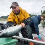 John Bohan, left, and Dusty Riesterer offload a dozen coho at the Golden North Salmon Derbys station at Amalga Harbor on Saturday, Aug. 24, 2019. (Michael Penn | Juneau Empire)