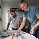 Seattle-based photographer Eirik Johnson, left, works with Ben Huff, a local photographer and editor of Ice Fog Press, on a hand-made book of Johnsons photographs titled Barrow Cabins on Wednesday, Aug. 21, 2019. (Michael Penn | Juneau Empire)