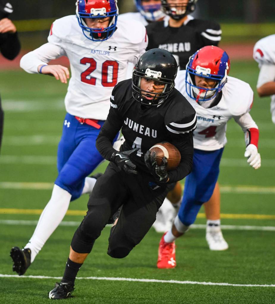 Juneaus Ali Beya, center, breaks away from Antelope Unions Jonathon Whitney, left, and Mickey Carrillo to score in the second quarter at Adair-Kennedy Memorial Field on Saturday, Aug. 24, 2019. Juneau won 56-18. (Michael Penn | Juneau Empire)