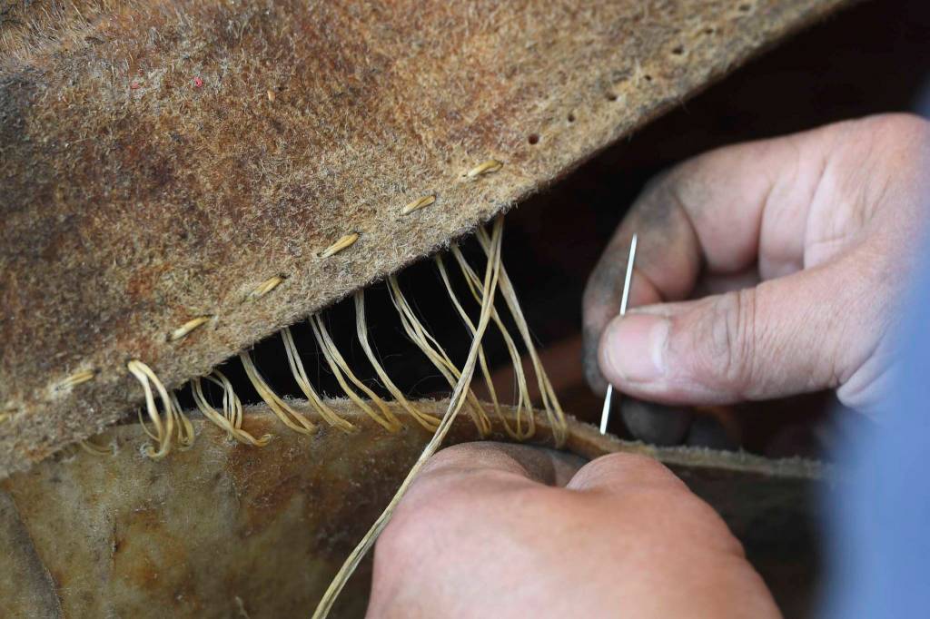 John Waghiyi Jr., artist and whaling captain, uses a synthetic twine to sew a walrus hide together at the Walter Soboleff Center on Tuesday, Aug. 27, 2019. the Waghiyis will demonstrate dances from their region from noon-1 pm, Wednesday, Aug. 28, for the public at SHI. (Michael Penn | Juneau Empire)
