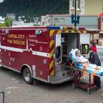 A Capital City Fire/Rescue crew transports a cruise ship passenger off the Radiances of the Seas downtown on Tuesday, August 14, 2018. (Michael Penn | Juneau Empire)
