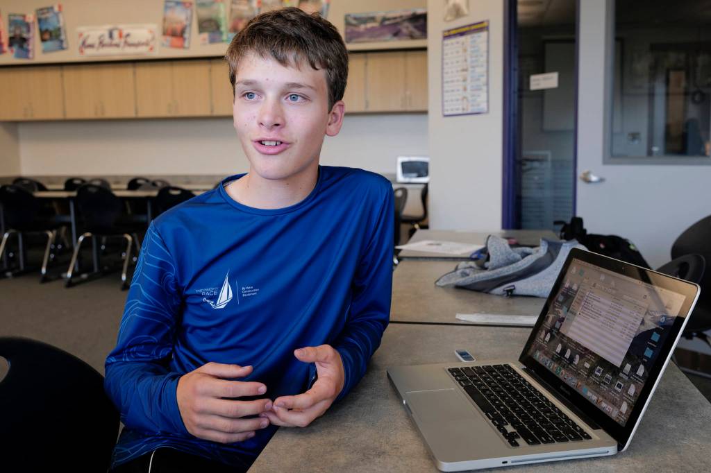 Alain Soltys-Gray, a sophomore at Thunder Mountain High School, talks about using a computer to make his logo design for the Juneau Huskies football team at TMHS on Wednesday, Aug. 28, 2019. (Michael Penn | Juneau Empire)