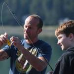 Dzantiki Heeni Middle School eighth-grader Riley Kellar, right, is helped by Teacher Bobby Jones while fishing for salmon at the Wayside Park on Channel Drive on Friday, Aug. 30, 2019. The fish will be used in a dog treat business the students are developing to raise money for a water filtering system to be used at the school. Two math teachers, Jones and Tennie Bentz, are having the students start four businesses as a way of teaching the use of math in the real world. (Michael Penn | Juneau Empire)