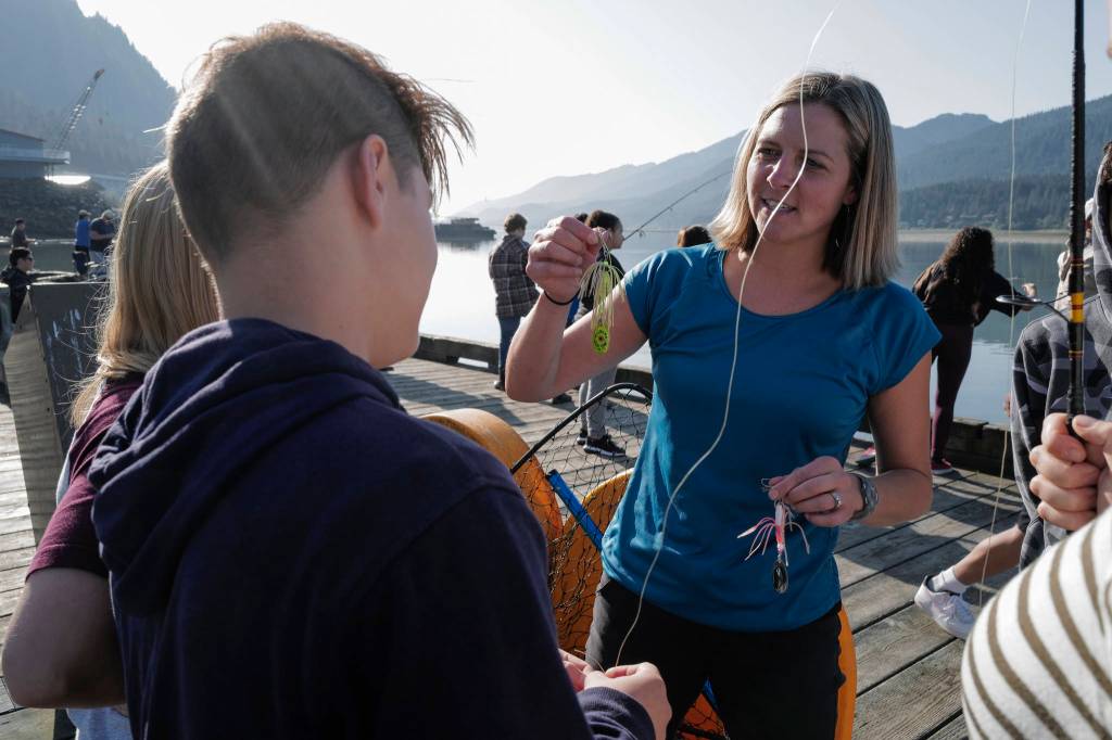 Dzantiki Heeni Middle School math teacher Tennie Bentz helps students pick lures while fishing for salmon at the Wayside Park on Channel Drive on Friday, Aug. 30, 2019. The fish will be used in a dog treat business the students are developing to raise money for a water filtering system to be used at the school. Two math teachers Bobby Jones and Tennie Bentz, are having the students start four businesses as a way of teaching the use of math in the real world. (Michael Penn | Juneau Empire)