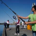 Dzantiki Heeni Middle School eighth-grader Pua Ahhney, right, and Elizabeth Eriksen fish for salmon at the Wayside Park on Channel Drive on Friday, Aug. 30, 2019. The fish will be used in a dog treat business the students are developing to raise money for a water filtering system to be used at the school. Two math teachers, Jones and Tennie Bentz, are having the students start four businesses as a way of teaching the use of math in the real world. (Michael Penn | Juneau Empire)