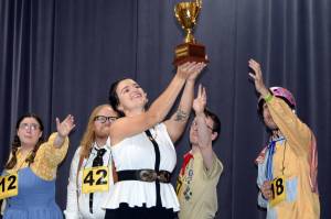 Logainne Schwartzandgrubenniere (Kristina Paulick), William Barfee (Nomi Saxton), Chip Tolentino (Zebadiah Bodine) and Leaf Coneybear (Felix Thillet) covet a trophy held aloft by Rona Liza Perretti (Jess Skiba) during rehearsals for The 25th Annual Putnam County Spelling Bee Tuesday, Sept. 3, 2019. (Ben Hohenstatt | Capital City Weekly)