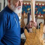 Local guitar maker George Gress holds a solid body electric guitar he made from repurposed wood at his home in March 2018. Gress will be part of this First Friday, Sept. 6. (Michael Penn | Juneau Empire File)