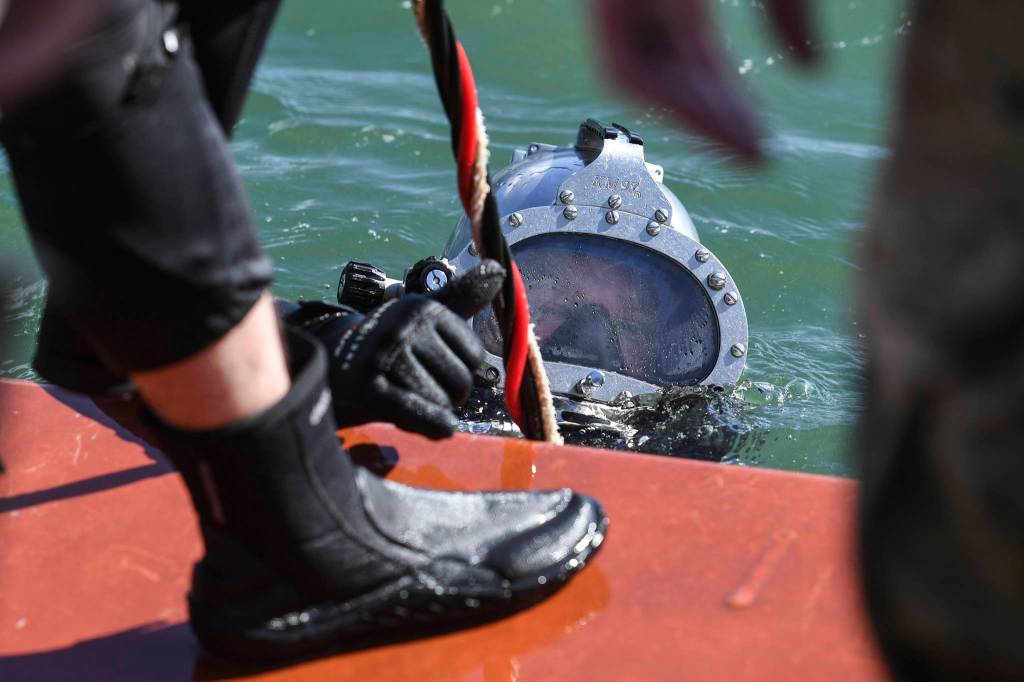 Members of the Armys 74th Engineer Dive Detachment work off a Juneau Harbormaster boat to retrieve lost crab pots in Gastineau Channel for the Douglas Indian Association/NOAA Marine Debris Project on Thursday, Sept. 5, 2019. The project aims to identify and remove derelict crab pots and their continued negative impact on wildlife and the environment. (Michael Penn | Juneau Empire)