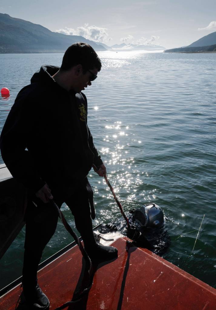 Members of the Armys 74th Engineer Dive Detachment work off a Juneau Harbormaster boat to retrieve lost crab pots in Gastineau Channel for the Douglas Indian Association/NOAA Marine Debris Project on Thursday, Sept. 5, 2019. The project aims to identify and remove derelict crab pots and their continued negative impact on wildlife and the environment. (Michael Penn | Juneau Empire)