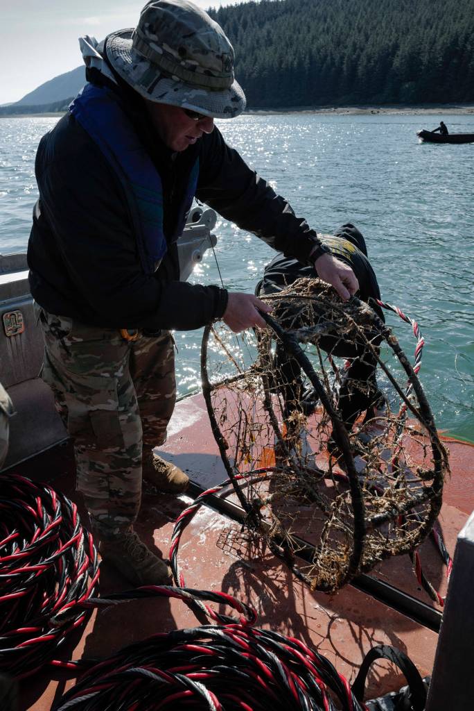 Members of the Armys 74th Engineer Dive Detachment work off a Juneau Harbormaster boat to retrieve lost crab pots in Gastineau Channel for the Douglas Indian Association/NOAA Marine Debris Project on Thursday, Sept. 5, 2019. The project aims to identify and remove derelict crab pots and their continued negative impact on wildlife and the environment. (Michael Penn | Juneau Empire)