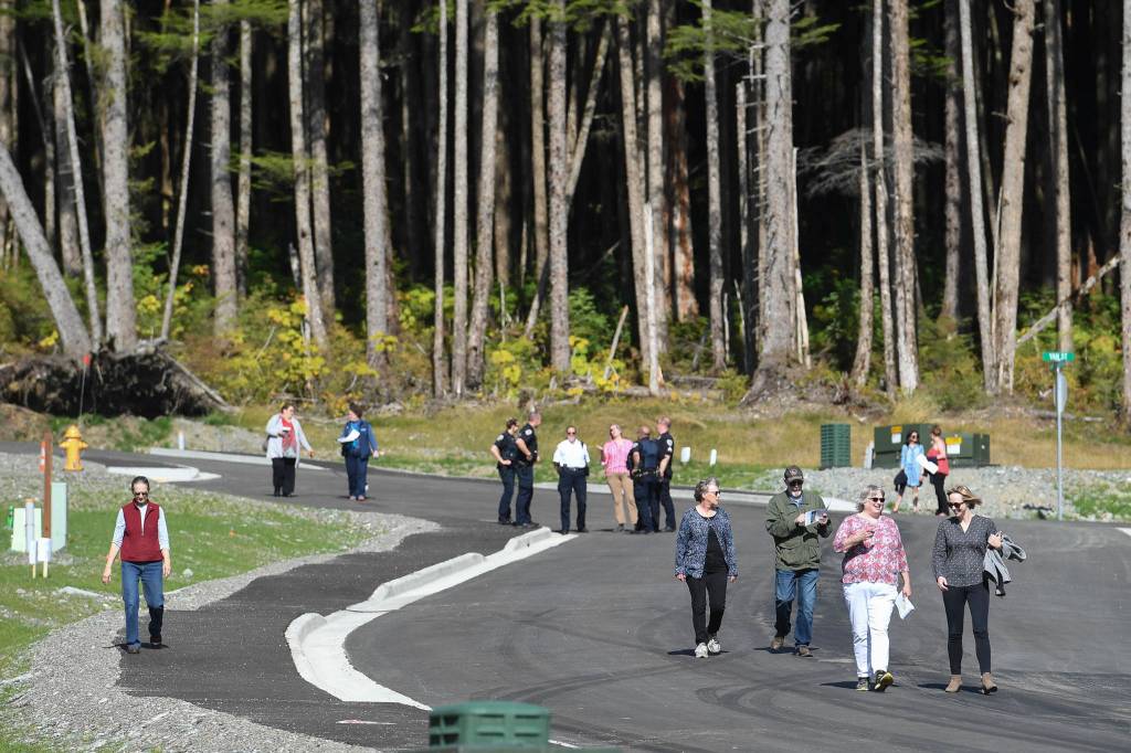 People walk along Karl Reishus Boulevard after a ribbon-cutting ceremony to commemorate the near completion of the Pederson Hill Subdivision on Friday, Sept. 6, 2019. Reishus was a Juneau Police Department officer who died in 1992 when he fell from a 40-foot tower during a training exercise. (Michael Penn | Juneau Empire)