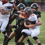 Juneaus Dawson Hickok, left, and Cole Jensen stop Wasillas quarterback Colton Lindquist in the first quarter at Adair-Kennedy Memorial Field on Friday, Sept. 6, 2019. Juneau won 63-0. (Michael Penn | Juneau Empire)