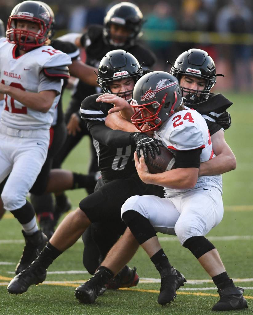 Juneaus Dawson Hickok, left, and Cole Jensen stop Wasillas quarterback Colton Lindquist in the first quarter at Adair-Kennedy Memorial Field on Friday, Sept. 6, 2019. Juneau won 63-0. (Michael Penn | Juneau Empire)