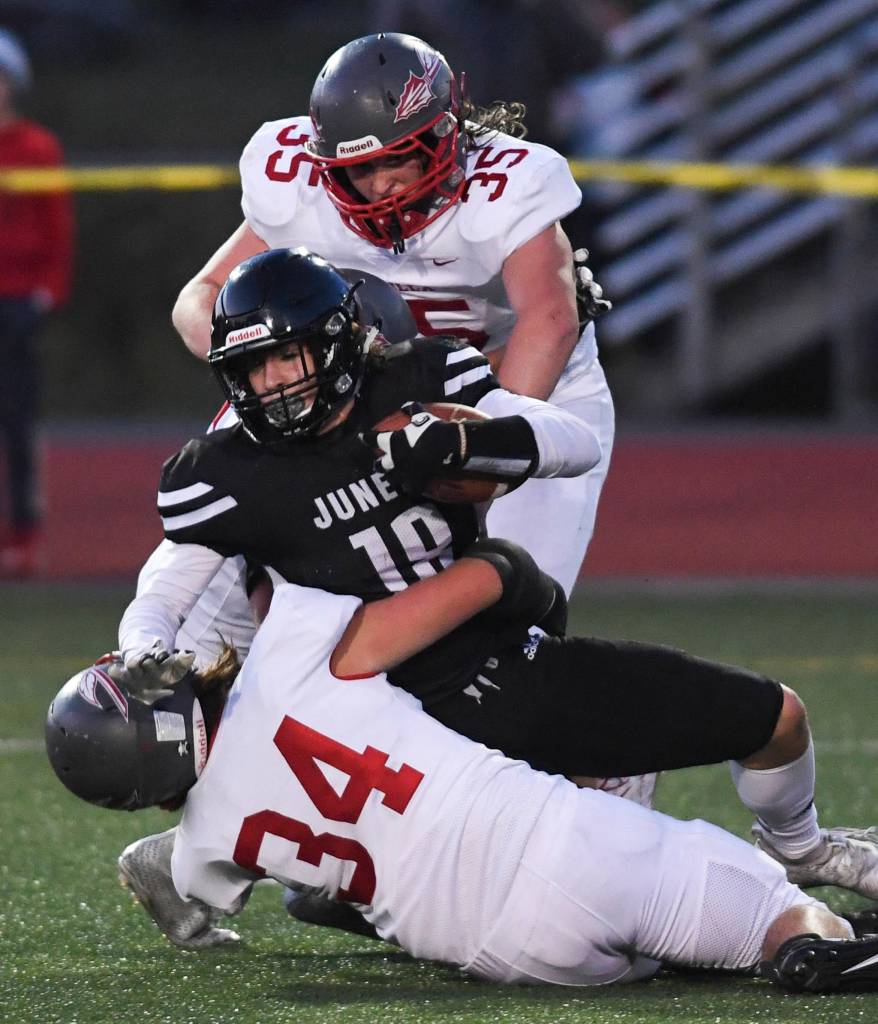 Juneaus Cooper Kriegmont is brought down by Wasillas Sawyer Drumm, bottom, and Tristan Wake in the second quarter at Adair-Kennedy Memorial Field on Friday, Sept. 6, 2019. Juneau won 63-0. (Michael Penn | Juneau Empire)