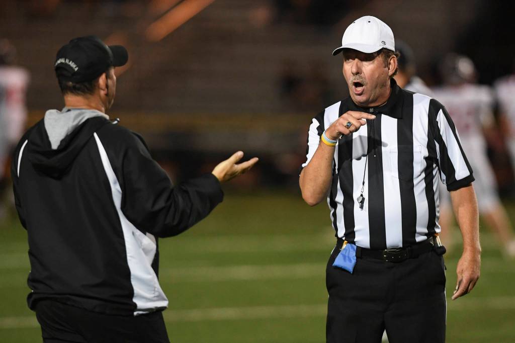 Juneaus head coach Rich Sjoroos exchanges words with referee Bob Simms as Juneau plays against Wasilla at Adair-Kennedy Memorial Field on Friday, Sept. 6, 2019. Juneau won 63-0. (Michael Penn | Juneau Empire)