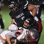 Juneaus Meki Toutaiolepo, center, tackles Wasillas Hunter Hayes in the third quarter at Adair-Kennedy Memorial Field on Friday, Sept. 6, 2019. Juneau won 63-0. (Michael Penn | Juneau Empire)