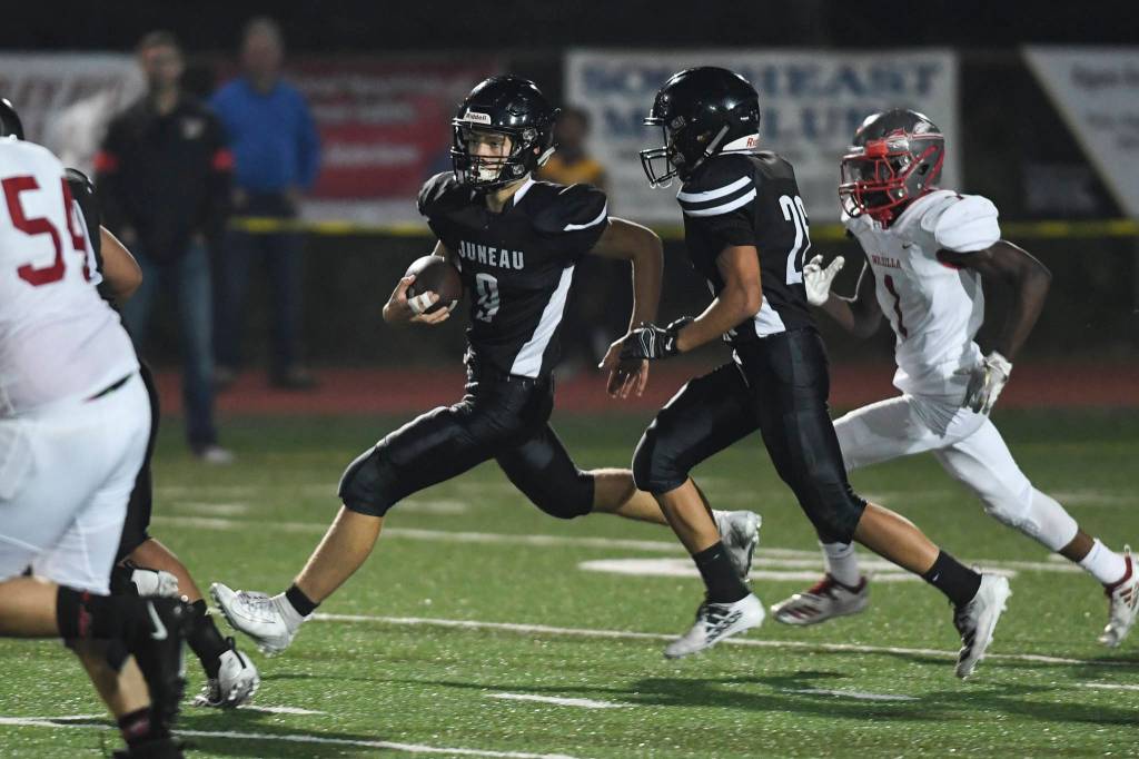 Juneaus Wallace Adams, center, runs after intercepting a pass against Wasilla in the third quarter at Adair-Kennedy Memorial Field on Friday, Sept. 6, 2019. Juneau won 63-0. (Michael Penn | Juneau Empire)