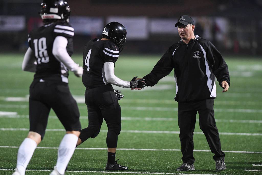 Juneaus head coach Rich Sjoroos congratulates Ali Beya, center, and Cooper Kriegmont in the third quarter as they compete against Wasilla at Adair-Kennedy Memorial Field on Friday, Sept. 6, 2019. Juneau won 63-0. (Michael Penn | Juneau Empire)